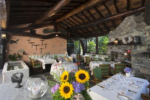 una sala da pranzo con tavoli bianchi e girasoli di Motto del Gallo a Taverne