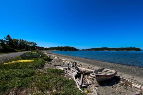 a group of boats sitting on the shore of a beach at The Beach House on Lopez Island in Lopez