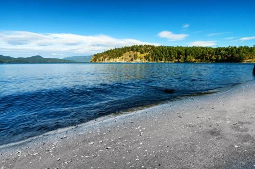 a large body of water with trees in the background at The Beach House on Lopez Island in Lopez
