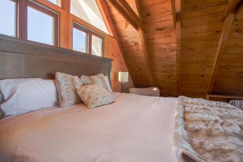 a bedroom with a large bed in a wooden cabin at The Eagle's Nest in Waldoboro