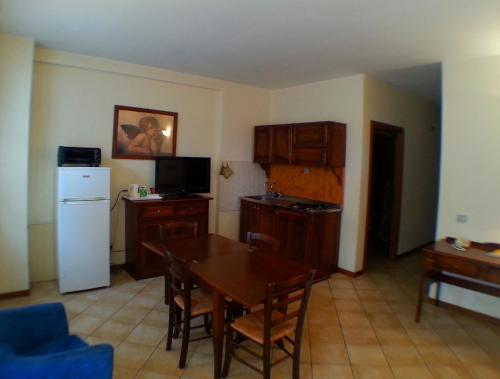 a kitchen with a dining room table and a refrigerator at Residence Le Meridiane in Siena