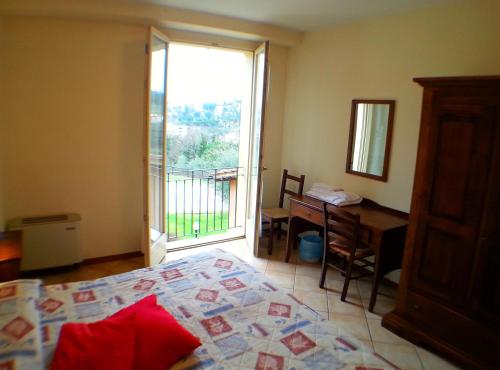 a bedroom with a bed and a desk and a window at Residence Le Meridiane in Siena