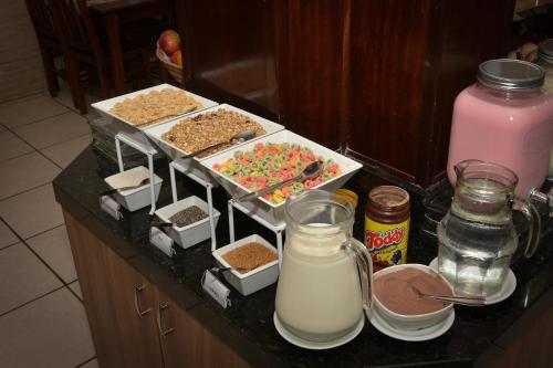 a counter top with some food and milk on it at HsHotelaria - Filial Bombinhas in Bombinhas