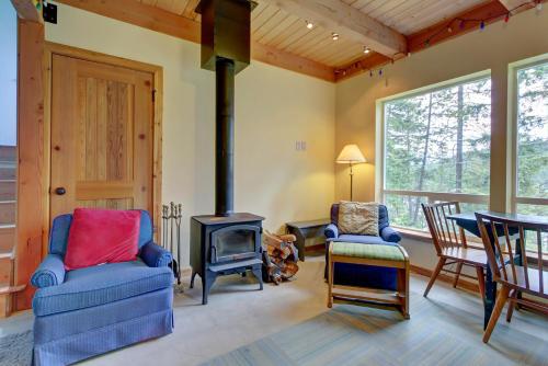 a living room with a wood stove and chairs at The Osprey Perch in Garfield