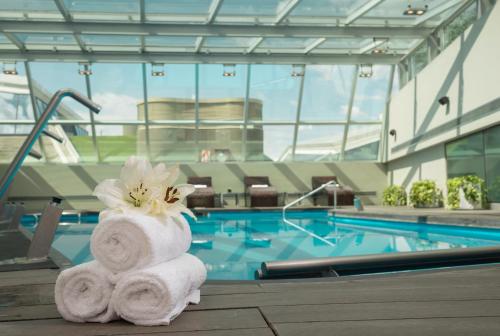 a stack of towels sitting next to a swimming pool at Hotel Pullman City Center Rosario in Rosario