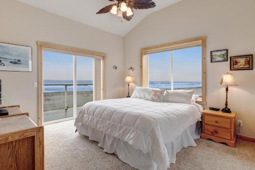a bedroom with a bed with a view of the ocean at Sunset Beach House in Gold Beach