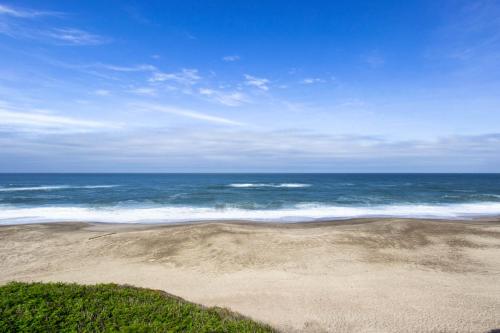 a sandy beach with the ocean in the background at At The Seaside in Lincoln Beach