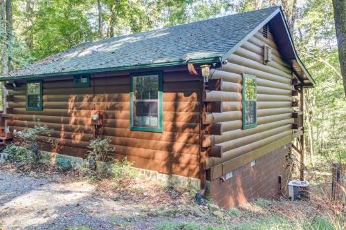 a log cabin in the woods with two windows at Tree Song Mountain Creek Cabin in Ellijay
