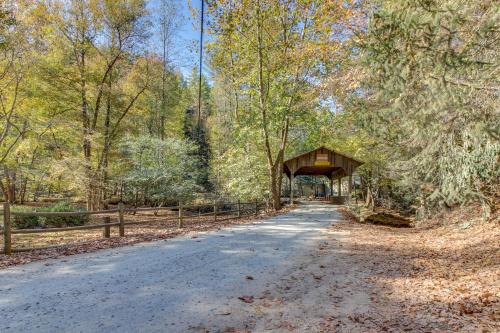 a road with a covered bridge in the woods at Tree Song Mountain Creek Cabin in Ellijay