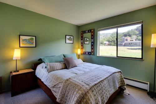 a bedroom with a large bed with a window at Bowsprit Retreat in Sea Ranch