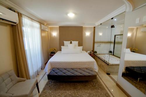 a hotel room with a bed and a bath tub at Hotel Capital Das Pedras in Teófilo Otoni