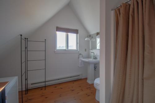 a bathroom with a toilet and a sink and a window at The Eagle's Nest in Waldoboro