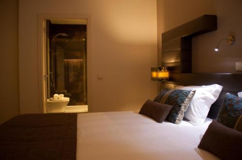 a bedroom with a large bed and a bathroom at Aqua Ria Boutique Hotel in Faro