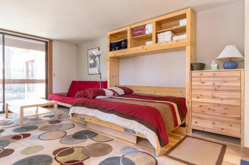 ein Schlafzimmer mit einem Etagenbett aus Holz und einem großen Fenster in der Unterkunft Aspen Grove Studio at Northstar in Truckee