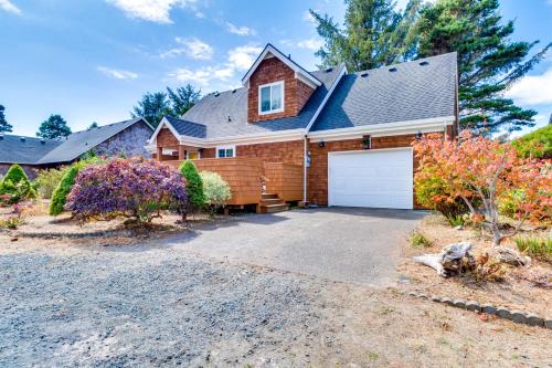 a house with a garage in front of it at Cozy Coast Modern in Nedonna Beach