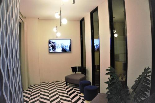 a waiting room with a chair and a tv on the wall at CREVICE HOTEL in Davao City