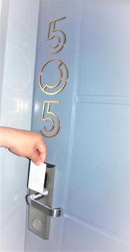 a person holding a piece of paper in a door handle at CREVICE HOTEL in Davao City