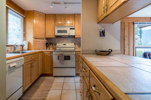 a kitchen with wooden cabinets and white appliances at Clear Water in Shrine Beach