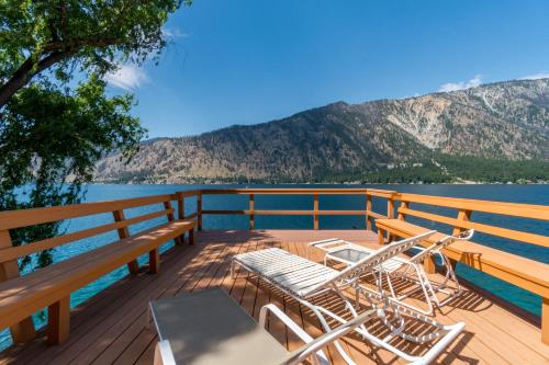 a deck with two chairs and a table on the water at Clear Water in Shrine Beach