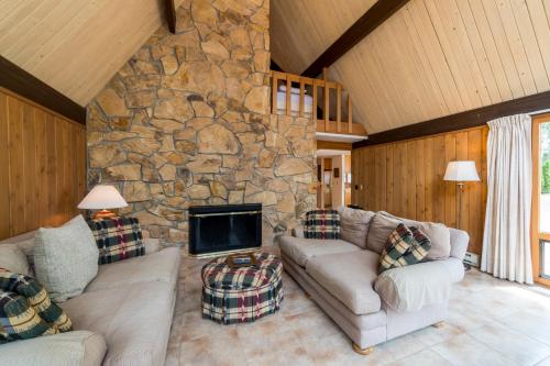 a living room with a stone fireplace and couches at Clear Water in Shrine Beach