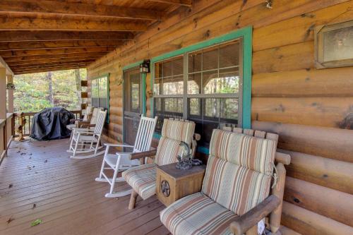 a porch of a cabin with chairs and a table at Tree Song Mountain Creek Cabin in Ellijay