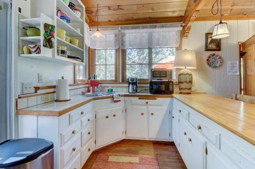 a kitchen with white cabinets and a wooden ceiling at The Crow's Nest in Idyllwild