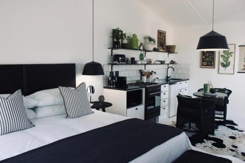 a bedroom with a bed and a kitchen with a table at Brenaissance Wine & Stud Estate in Stellenbosch