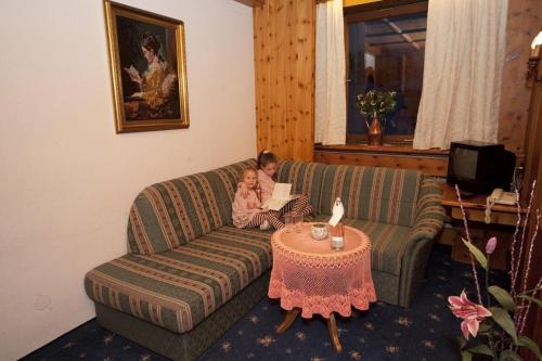 two children sitting on a couch in a living room at Hotel Metzgerwirt in Fieberbrunn