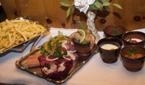 a plate of food on a table with french fries at Hotel Metzgerwirt in Fieberbrunn