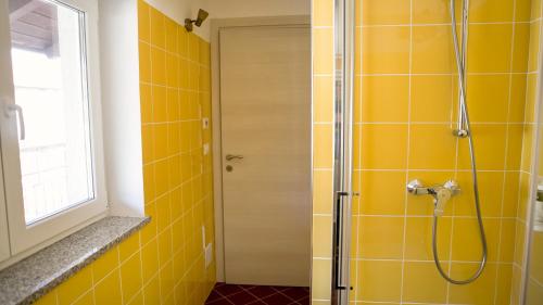a bathroom with a shower with yellow tiles at Il nido dei gufi in San Maurizio Canavese