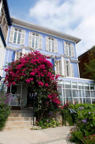a blue house with pink flowers in front of it at Zerohotel in Valparaíso