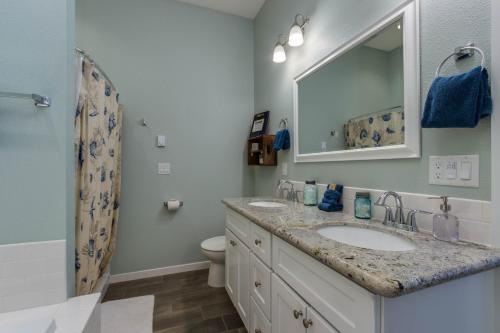 a bathroom with a sink and a mirror and a toilet at Knot a Care in Lincoln City