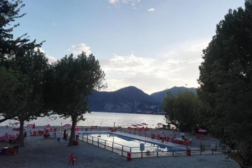 a group of people standing around a swimming pool on a lake at Casa Tiziana in Sovere