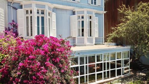 a house with pink flowers in front of it at Zerohotel in Valparaíso