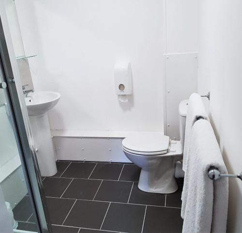 a white bathroom with a toilet and a sink at The Dorchester Hotel & serviced apartments in Hull