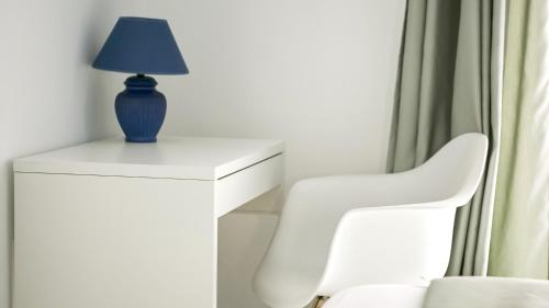 a blue lamp on a white table next to a white chair at Il nido dei gufi in San Maurizio Canavese