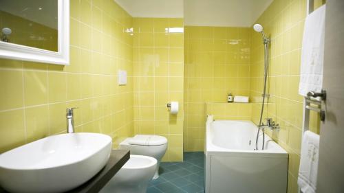 a bathroom with a sink and a toilet and a tub at Il nido dei gufi in San Maurizio Canavese