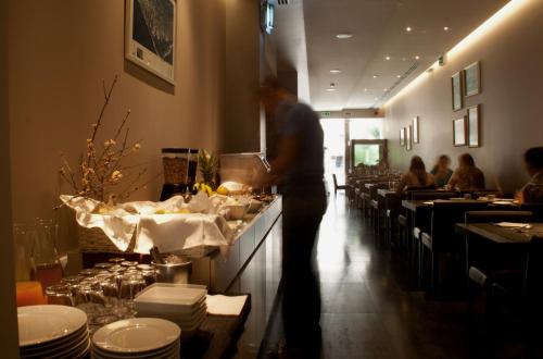 a man standing at a counter in a restaurant at Aqua Ria Boutique Hotel in Faro