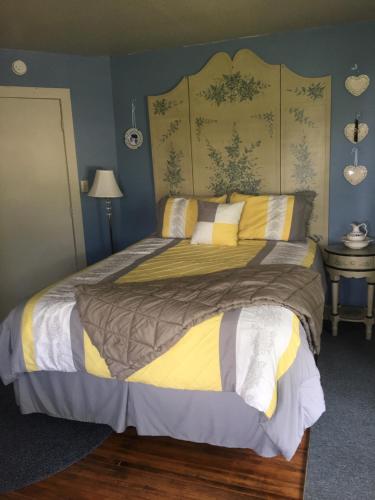 a bedroom with a large bed with yellow and white pillows at Glass Magnolia Bed & Breakfast in Interlaken