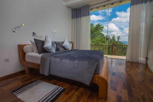 a bedroom with a bed and a large window at Villa Vajrapani in Kandy