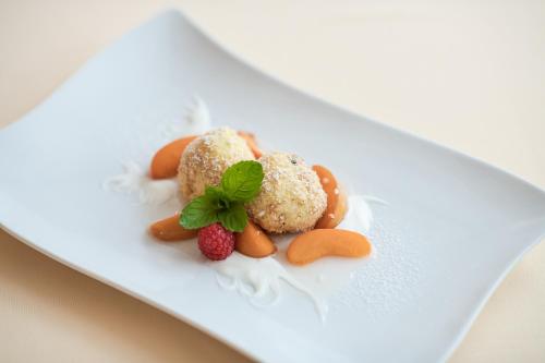 a white plate with desserts on a white plate at Hotel Zum Mohren in Resia