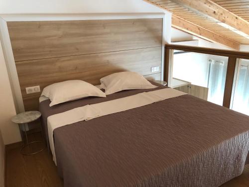 a bedroom with a large bed with a wooden headboard at Résidence Porto Marine in Porto Ota