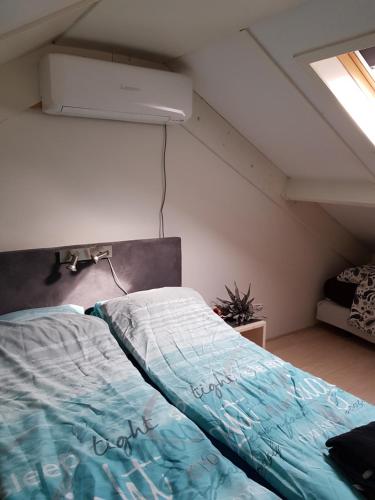 um quarto com uma cama num sótão em Vakantiehuis B&B de Bosrand Groesbeek em Groesbeek