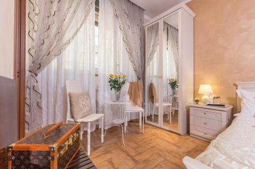 a bedroom with a table and chairs and a mirror at Starry Rome Guest House in Rome