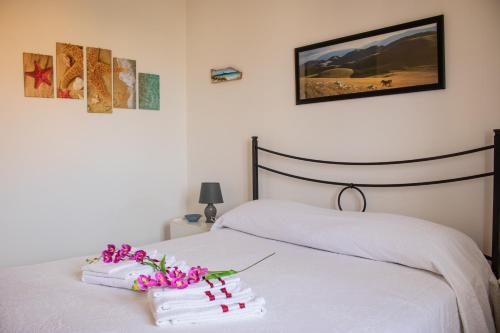 - une chambre avec un lit, des serviettes et des fleurs dans l'établissement SOL LEONE, à Porto Torres