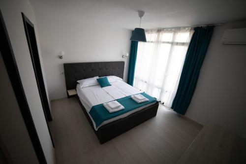 a bedroom with a bed with two towels on it at Vila La Faleza Dubova in Dubova