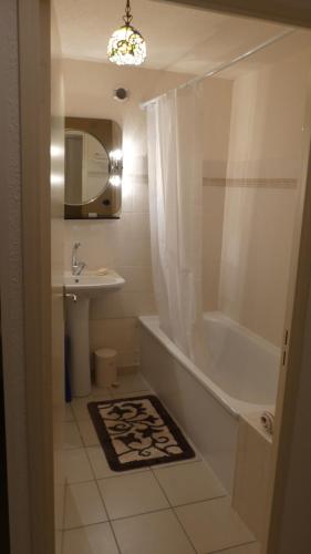 une salle de bain avec une baignoire, un lavabo et un miroir dans l'établissement Maison T3 à Banyuls sur mer avec vue mer/montagne, à Banyuls-sur-Mer