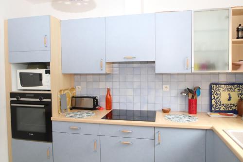 une cuisine avec des armoires blanches et un comptoir dans l'établissement Maison T3 à Banyuls sur mer avec vue mer/montagne, à Banyuls-sur-Mer