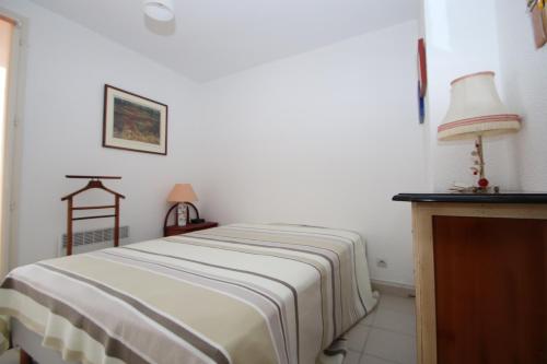 une chambre avec un lit et une table avec une lampe dans l'établissement Maison T3 à Banyuls sur mer avec vue mer/montagne, à Banyuls-sur-Mer