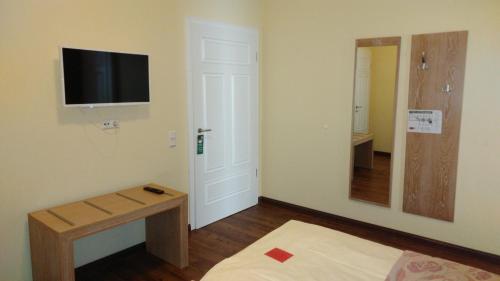 a room with a bed and a television on a wall at Dreimädelhaus - Kirchseelte in Kirchseelte